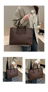 Detail view of large brown tote bag with M-letter monogram and leather handles