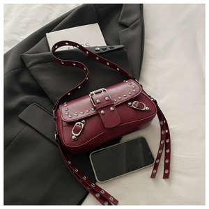 Dettaglio della borsa in ecopelle rosso vino con borchie argentate e fibbie in metallo
