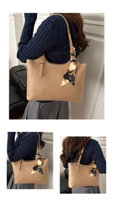 Detail of camel tote bag featuring a geometric silk scarf and elegant gold buckle hardware