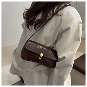 Close-up of a dark brown crocodile texture shoulder bag with golden U-shaped metal buckle