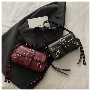 Dettaglio di borse a tracolla in pelle con borchie in bordeaux e nero stile punk