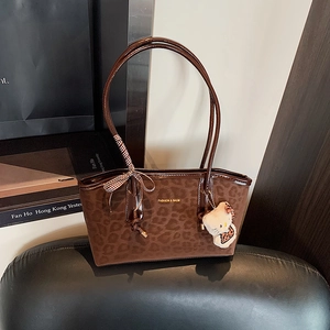 Borsa tote in camoscio leopardato marrone con fiocco e ciondolo di peluche su base nera