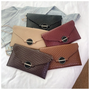Detailed view of woven leather texture and elegant gold metal chain straps on the crossbody bag