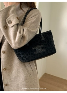 Detail of black leopard print tote bag with metal logo on elegant wool coat