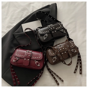 Dettaglio di tre borse a spalla vintage con borchie nei colori nero, marrone e rosso