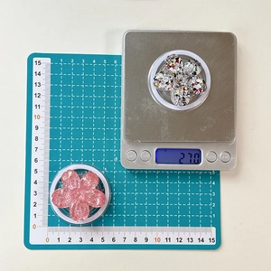 Macro view of two floral phone grips showing 4.5cm diameter on a green scale mat