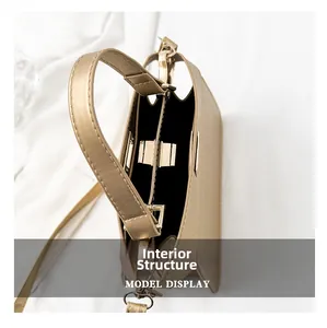Innenansicht der goldenen Kroko-Handtasche mit Metalldrehverschluss und schwarzem Futter