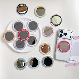 Colorful round magnetic makeup mirror phone grips displayed on a white ceramic plate