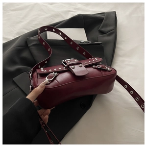 Dettaglio della borsa punk rosso scuro con borchie argentate e fibbia in metallo