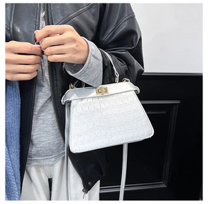 Détails du cuir argenté à motif crocodile et du fermoir doré du sac à main