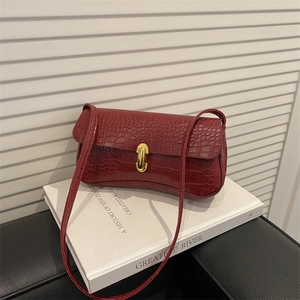 Deep red crocodile embossed baguette underarm bag with gold metallic twist lock