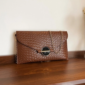 Brown woven leather envelope crossbody bag with elegant gold chain and metal lock