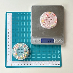 Macro detail of glitter fruit phone grip showing strawberry and lemon resin inlay pattern
