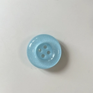 Macro detail of light blue glittery button phone socket with a smooth resin finish