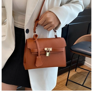 Detail of caramel lychee grain leather handbag with gold twist lock and hardware