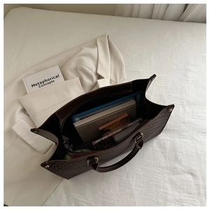 Top view of large brown tote bag interior storage with tablet and books
