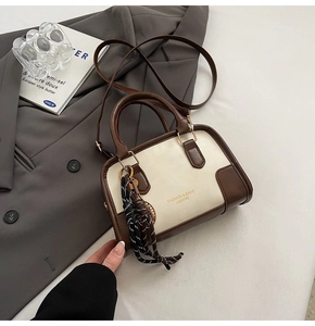 Detail of vintage cream and brown handbag with polka dot scarf and fashion logo