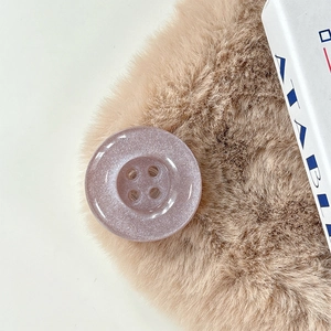 Macro view of a lilac button phone grip with fine glitter finish and a four-eye design