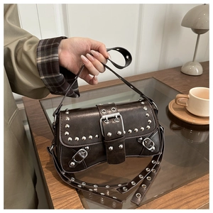 Dettaglio della borsa punk marrone vintage con borchie argentate e fibbia centrale