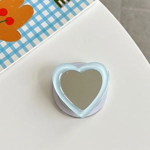 Macro detail of heart-shaped mirror phone grip with light blue translucent outer edge