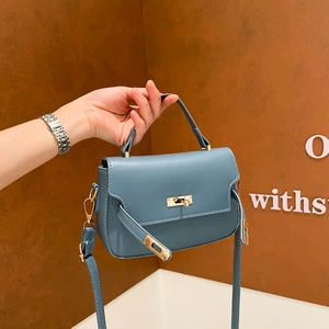 Sac à main en cuir bleu avec fermoir doré et une bandoulière amovible réglable