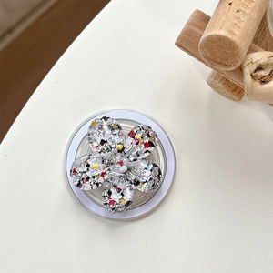 Macro shot of glittery sequin flower phone grip with expandable base and colorful crystals