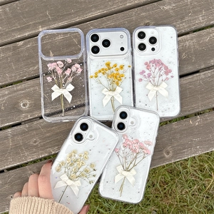 Sparkly iPhone case featuring real pressed flowers and a delicate white ribbon bow