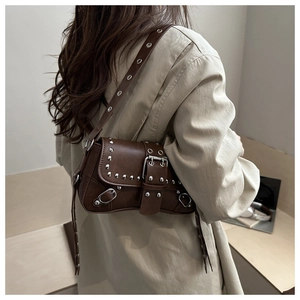 Borsa a spalla marrone con borchie in similpelle abbinata a un trench beige