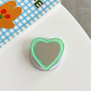 Detail of mint green heart-shaped phone grip with built-in mirror and folding base