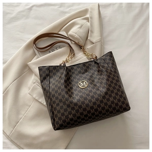 Détail du cabas vintage marron avec motif M et logo métallique doré élégant