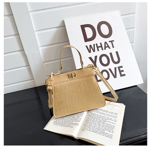 Detalle del bolso Kelly oro champán con textura de cocodrilo y hebilla de metal dorado