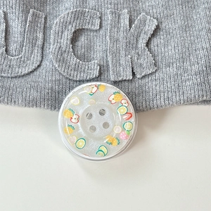Detail of glittery button phone socket with colorful miniature fruit slices inside