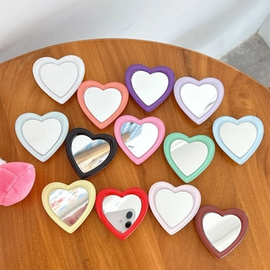 Colorful heart-shaped phone grip mirrors in 13 candy colors on a wooden surface