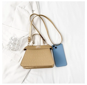 Mini sac à main texture crocodile avec téléphone pour échelle de taille en champagne