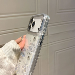 Detail of 3D bubble ornaments and silver glitter stars on transparent iPhone case