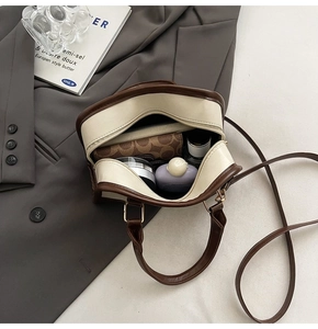 Detail view of the spacious interior of this retro color-block bag showing daily essentials