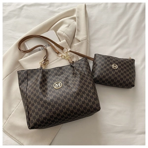 Détail du sac cabas imprimé avec anses en cuir, chaîne en métal et pochette assortie