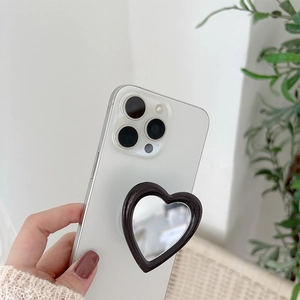 Heart-shaped mirror phone grip stand in black frame on a smartphone back