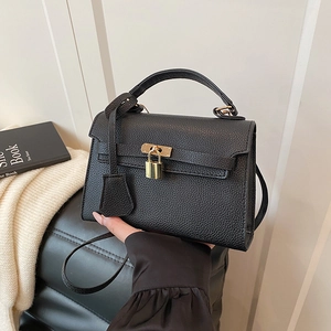 Fashionable black pebbled leather trapezoid handbag with gold padlock and top handle