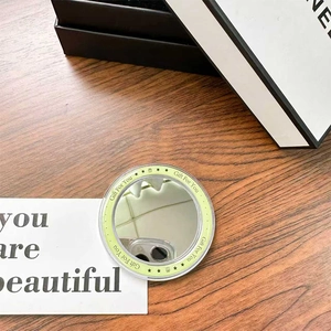 Detail of round magnetic phone socket makeup mirror in light yellow with Gift For You text