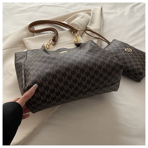 Détail du cabas marron avec motif lettre M, garniture dorée et pochette assortie