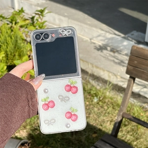 Detail of Galaxy Z Flip case featuring 3D resin cherries and glittering bow decorations