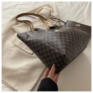 Détail de l'ensemble cabas et pochette assortie avec motif monogramme vintage
