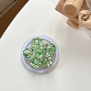 Close-up of a 3D floral phone socket with green sequins and a white collapsible base