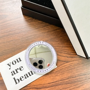 Close-up of a round magnetic phone mirror stand with purple Gift For You design