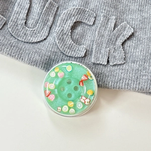 Close-up of a green resin button phone socket with fruit slices and a gift card background