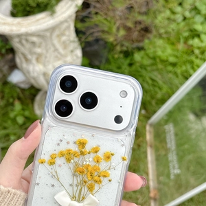 Detail of iPhone case with real yellow pressed flowers, glitter, and white ribbon bow