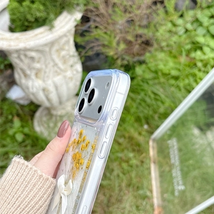 Detail of iPhone case featuring real yellow dried flowers and white satin bow decoration