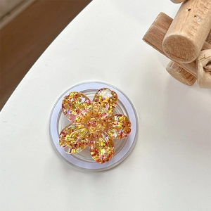 Detail of sequin cherry blossom phone grip with golden glitter and 3D floral resin design