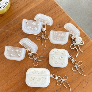 Glitter clear AirPods case with silver flower and star charms on a wooden surface